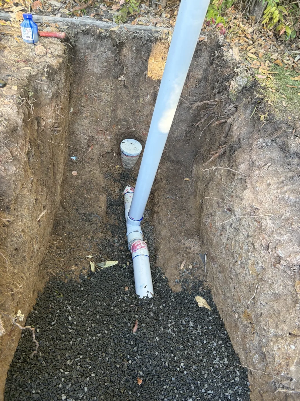 PVC drainage junction in excavated trench