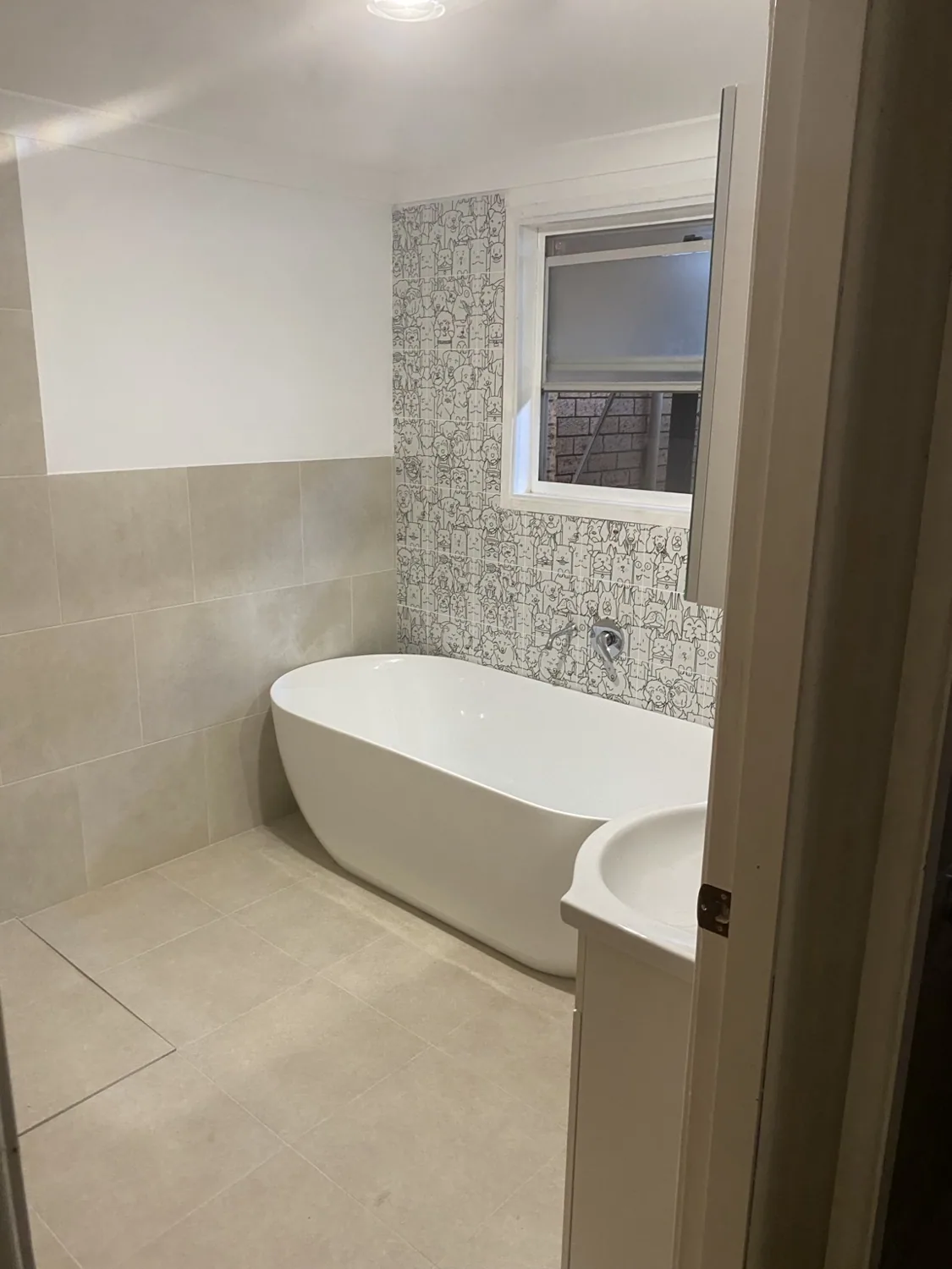 Freestanding bath, tiled floor and feature wall